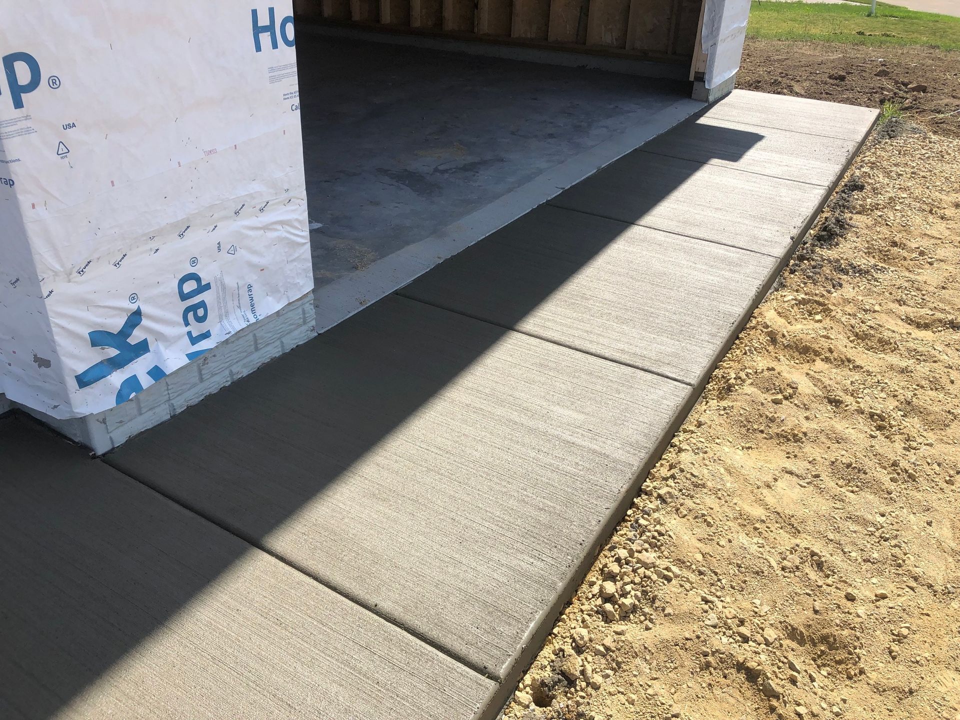 A concrete walkway is being built in front of a building.