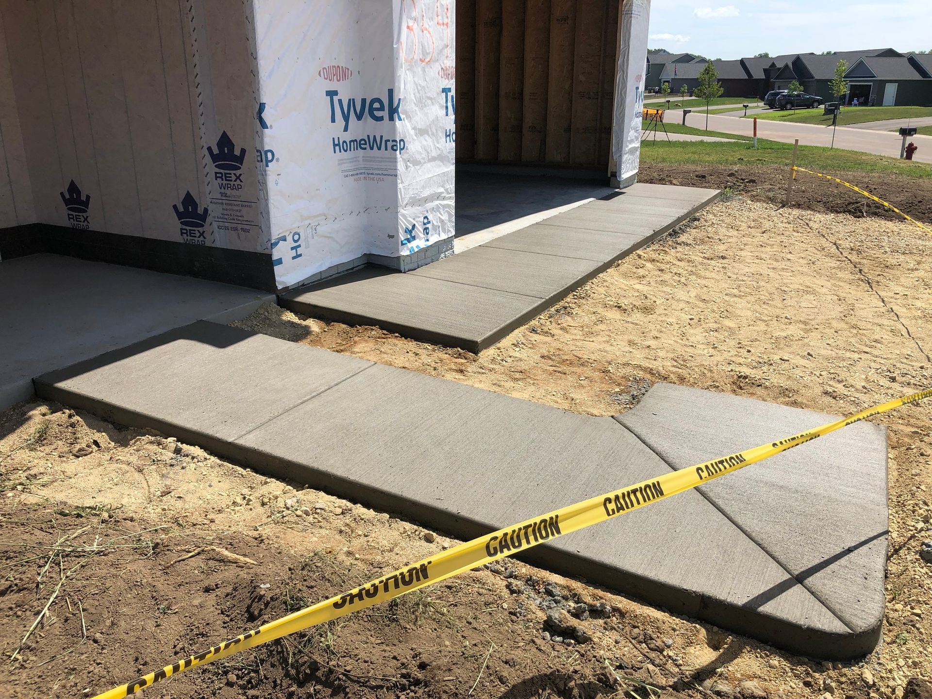 A concrete walkway is being built in front of a house.