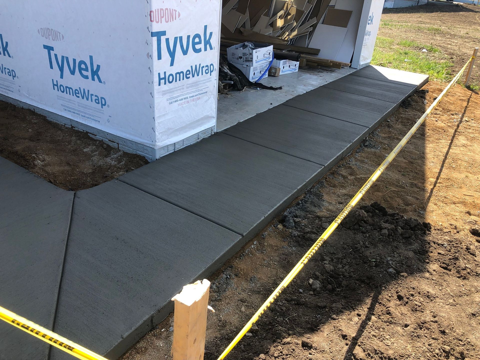 A concrete walkway is being built in front of a building.