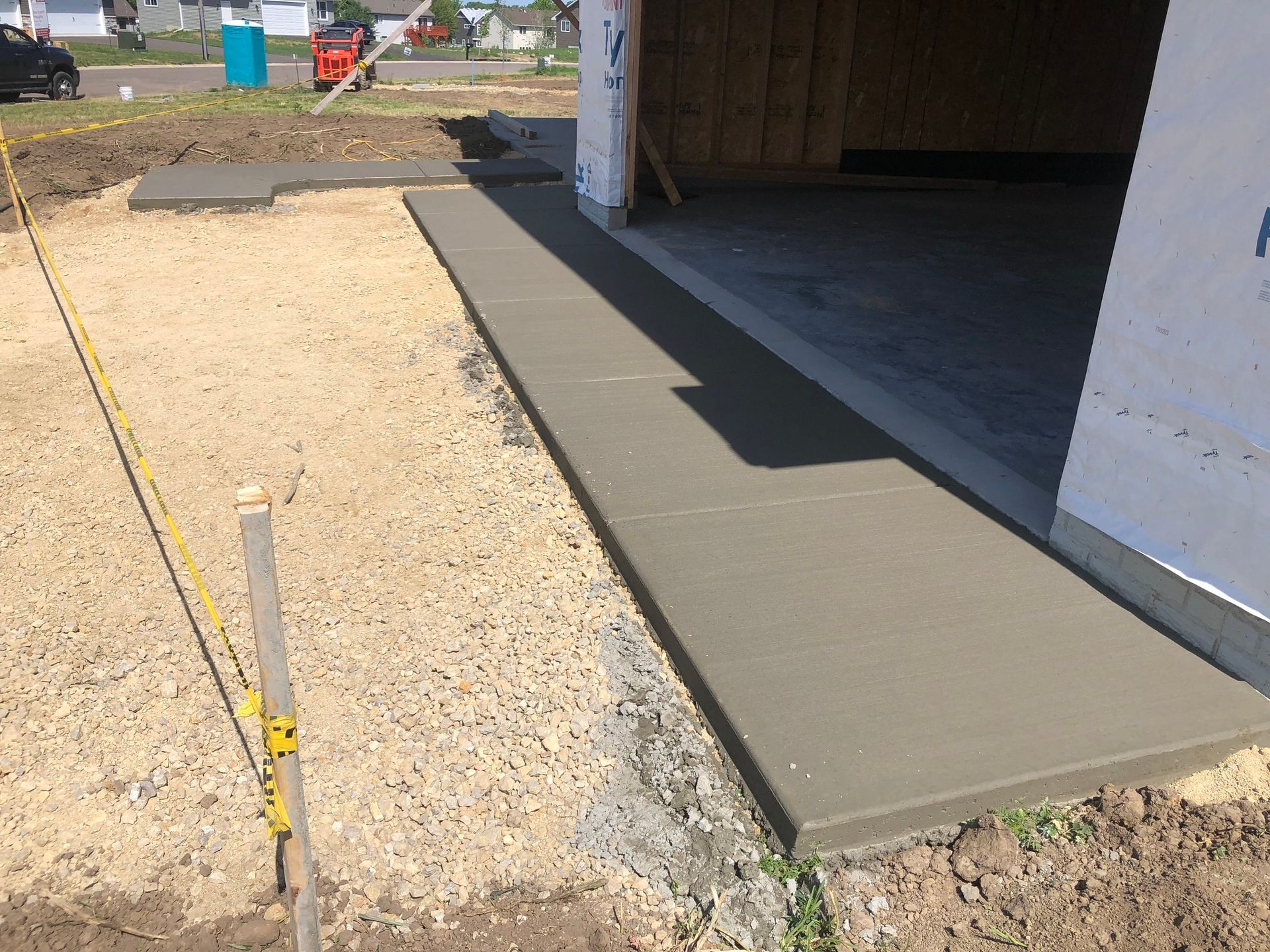 A concrete walkway is being built in front of a garage.