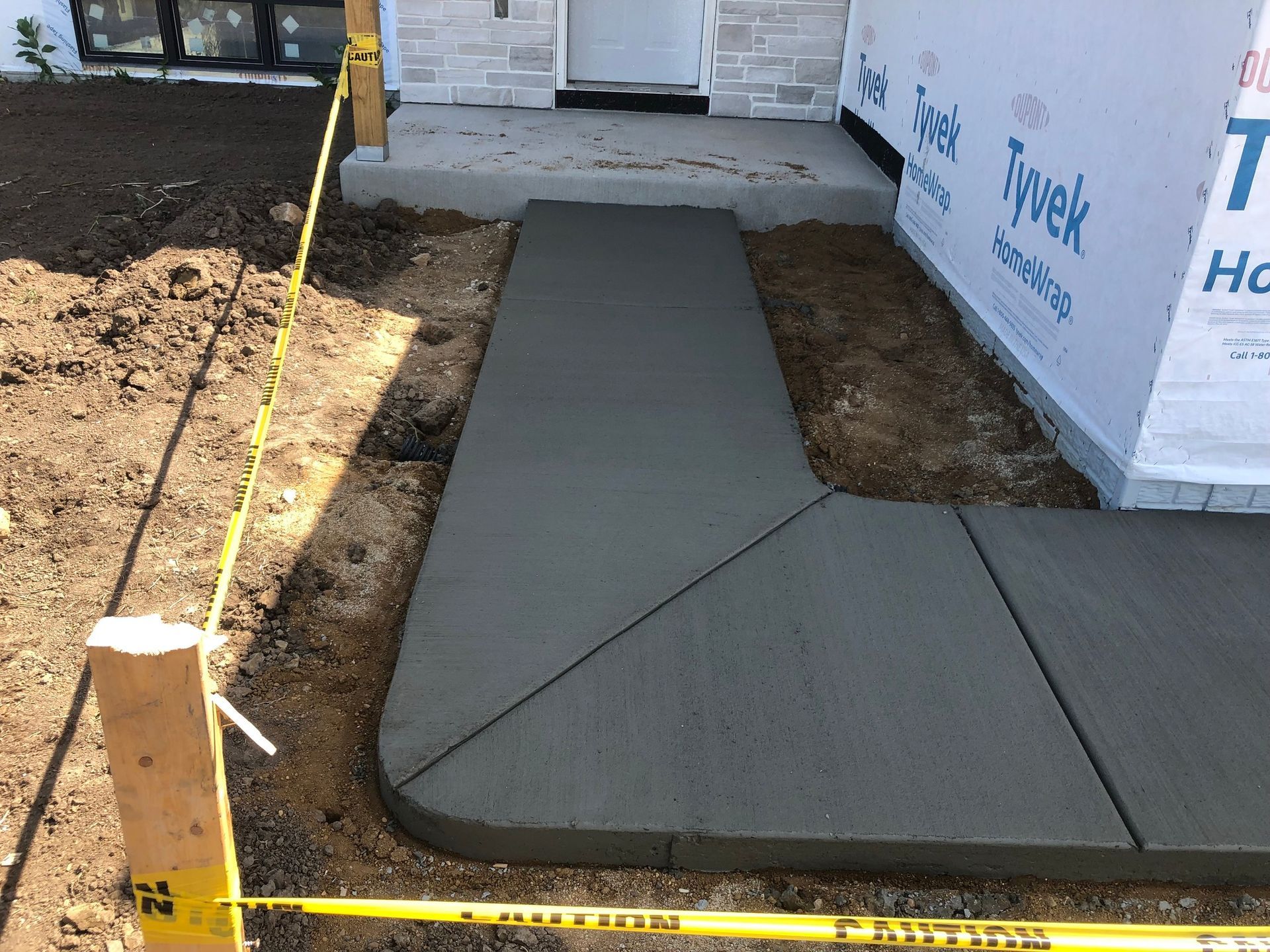A concrete walkway is being built in front of a house.