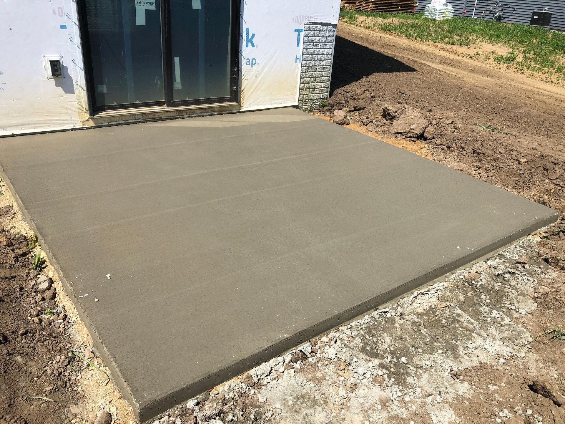 A concrete walkway is being built in front of a house.