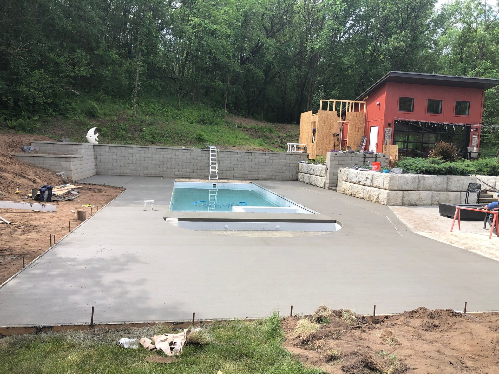 A swimming pool is being built in the backyard of a house.