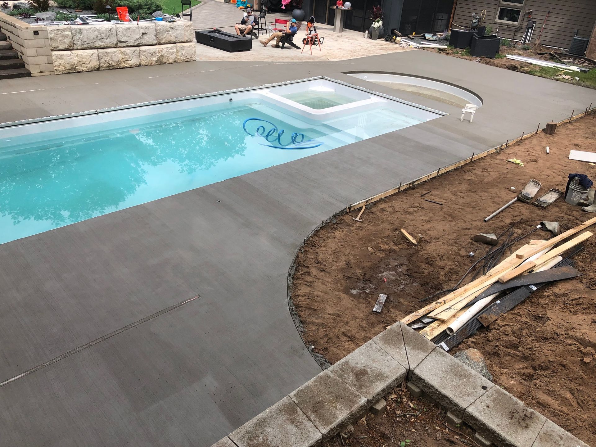 A large swimming pool is being built in a backyard.