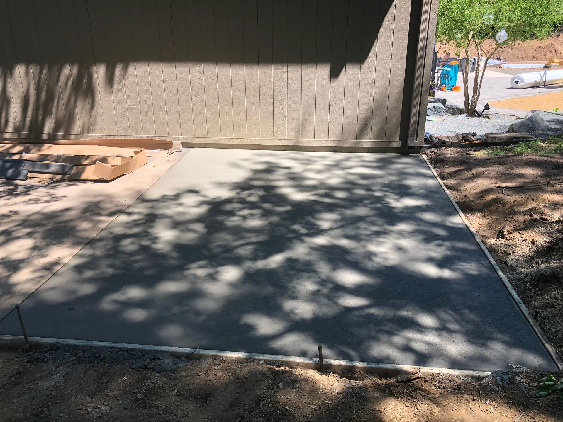 A concrete driveway is being built in front of a house.