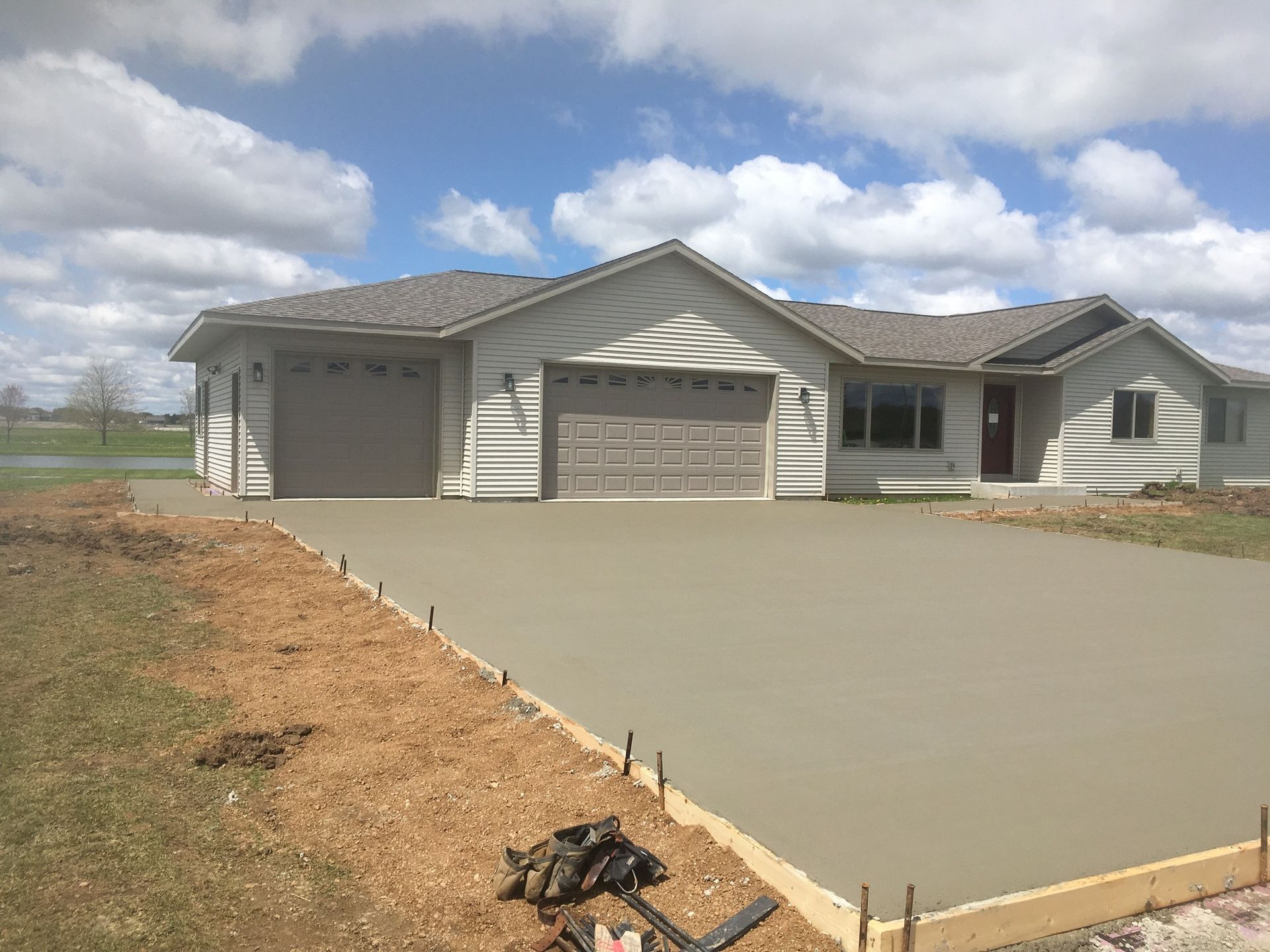 A house with a concrete driveway in front of it.