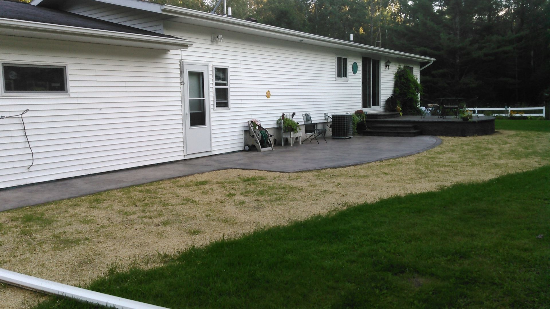 A white house with a large lawn in front of it.