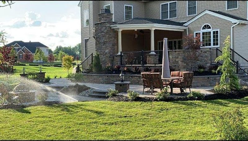 A large house with a lawn sprinkler in front of it.
