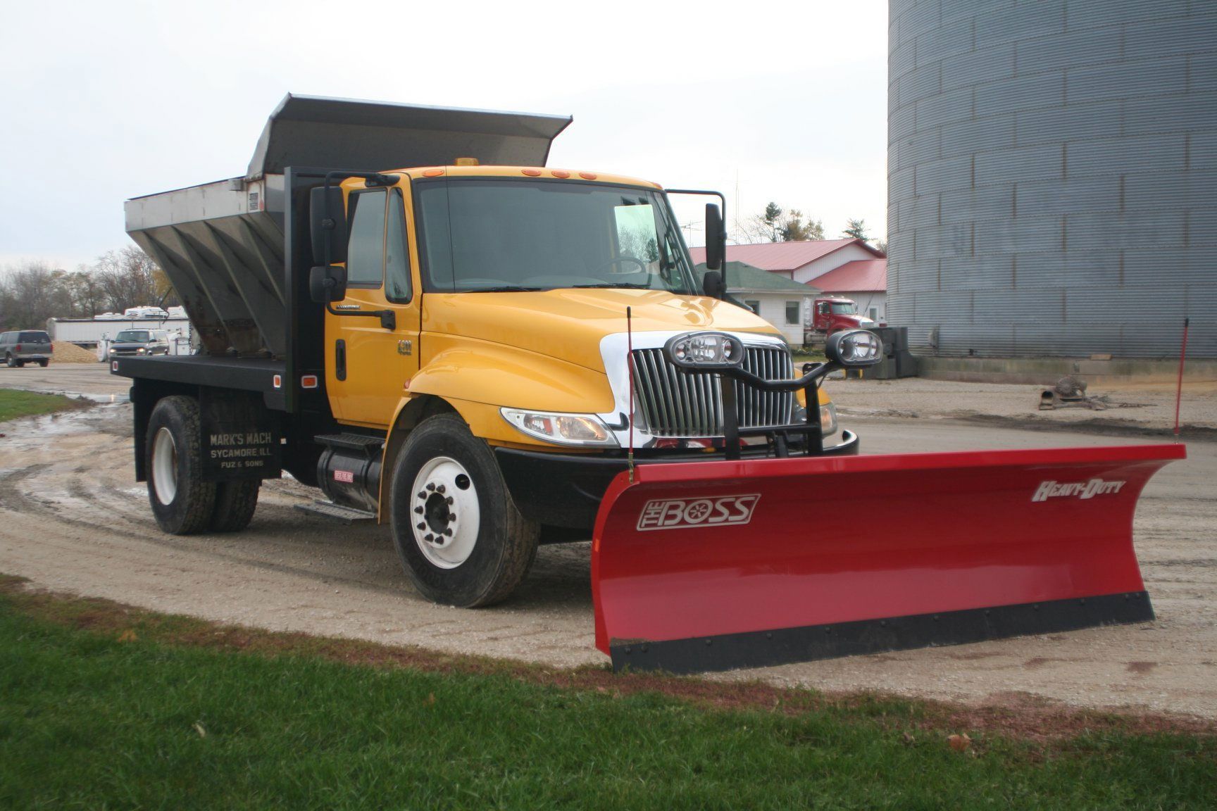 a yellow dump truck with a snow plow attached to it