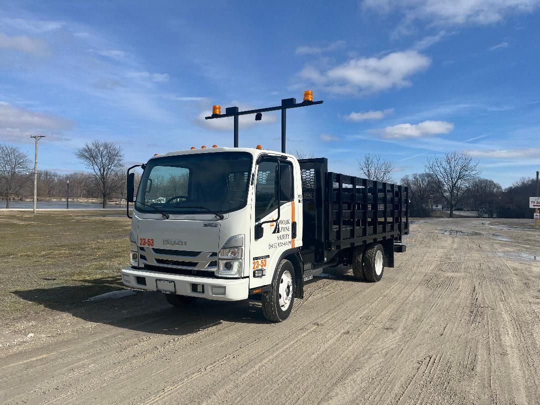 a white truck is parked on the side of a dirt road
