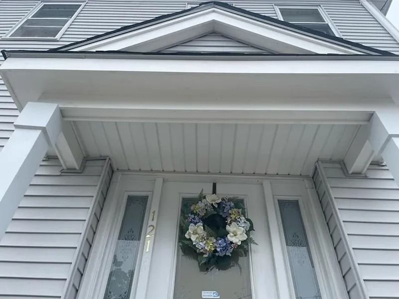 White house entrance with wreath on door.