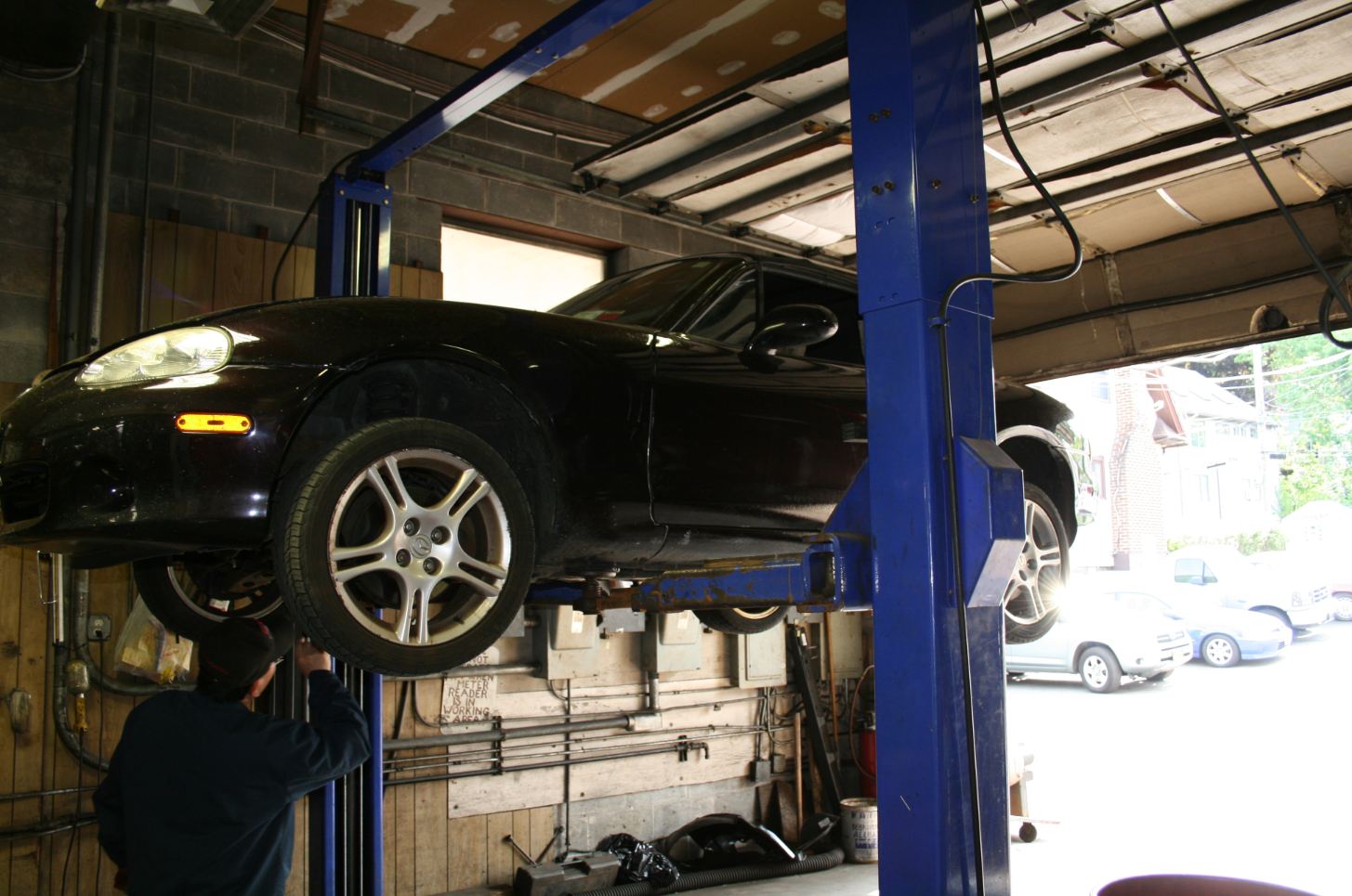 A black car is on a blue lift in a garage