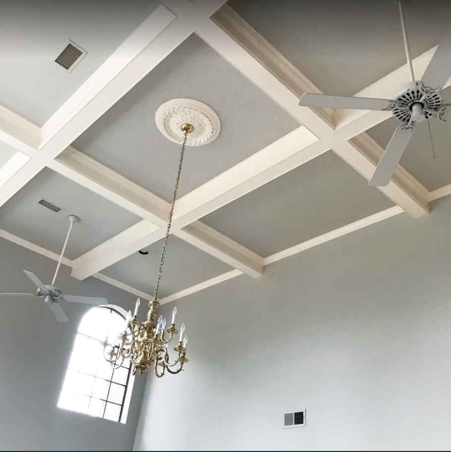 A room with a ceiling fan and a chandelier.