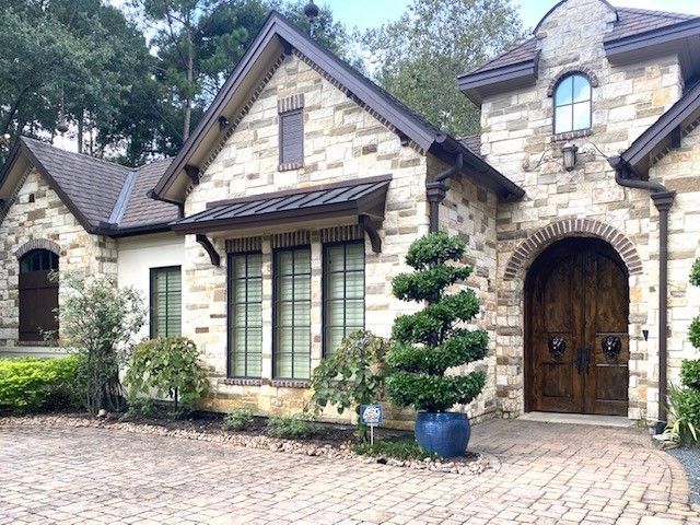 A large brick house with a tree in front of it.