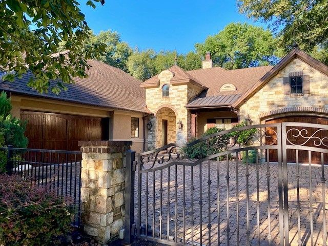 A large house with a wrought iron gate in front of it.