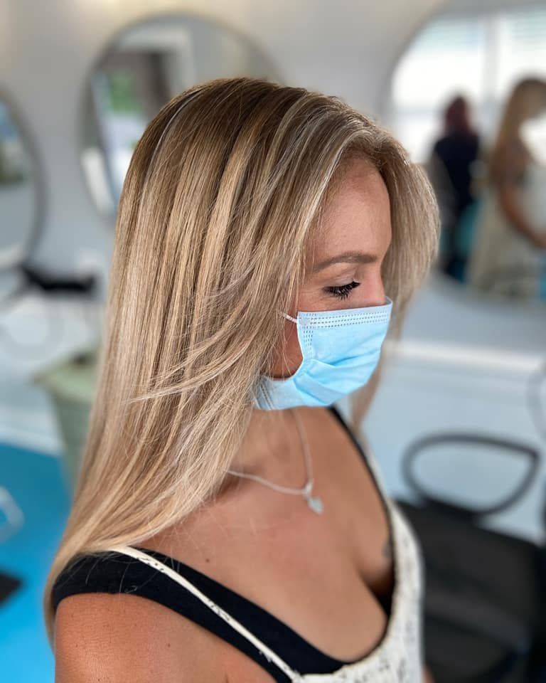 A woman wearing a face mask in a salon.