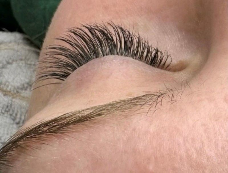 A close up of a woman 's eye with long eyelashes.