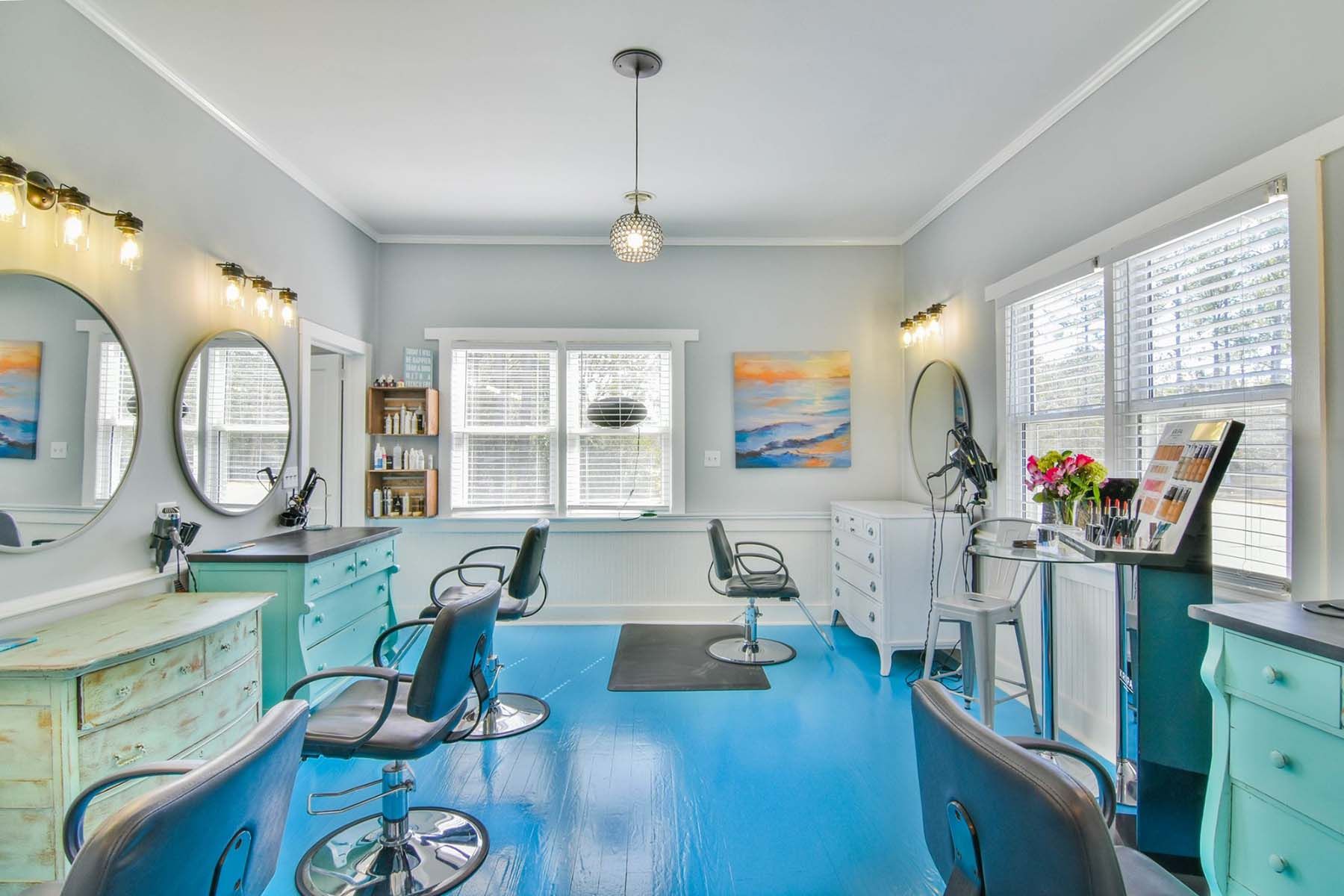 A hair salon with blue floors and chairs.