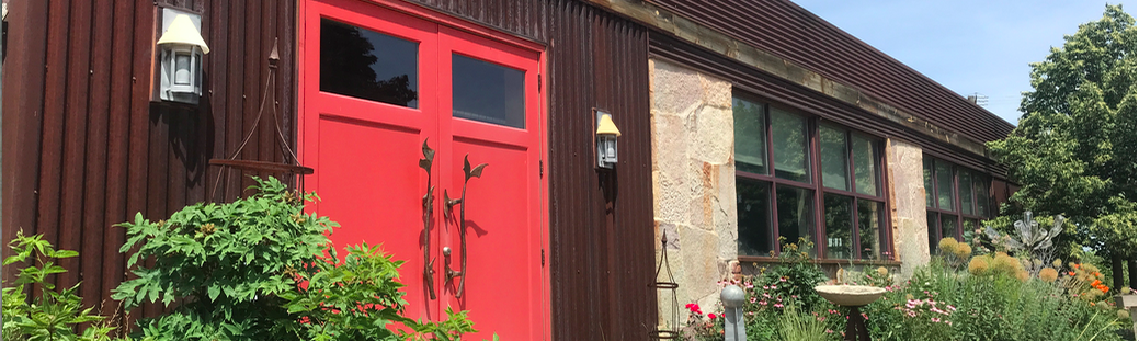 A red door is on the side of a building.
