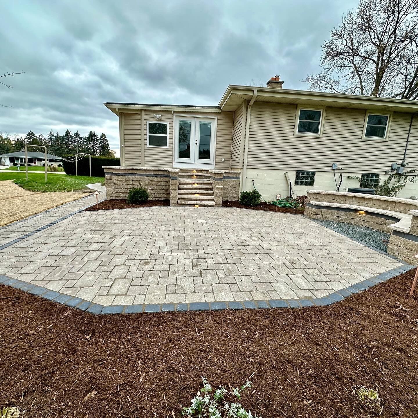 a house with a patio and stairs in front of it .