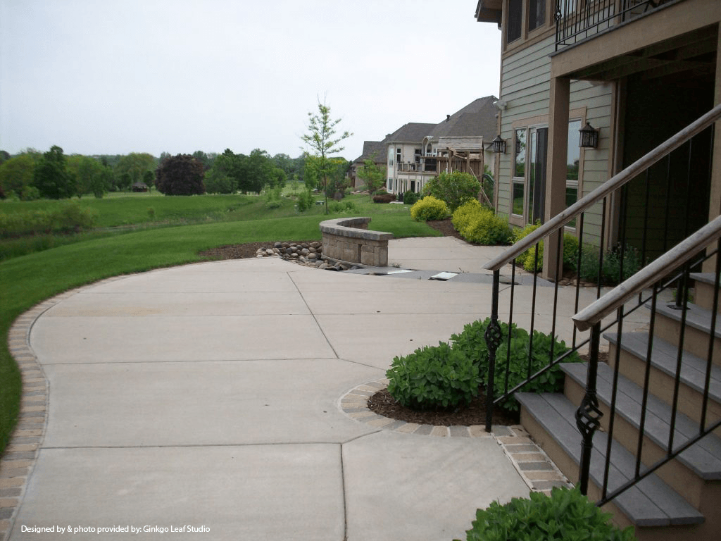 A concrete patio with stairs leading up to a house