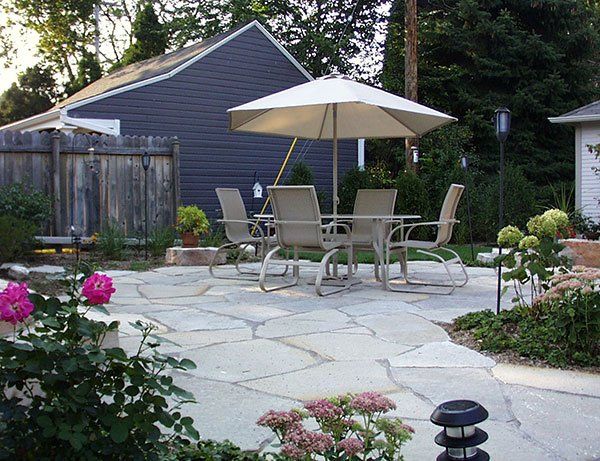 A patio with a table and chairs under an umbrella