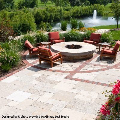 A patio with a fire pit and chairs designed by ginkgo leaf studio