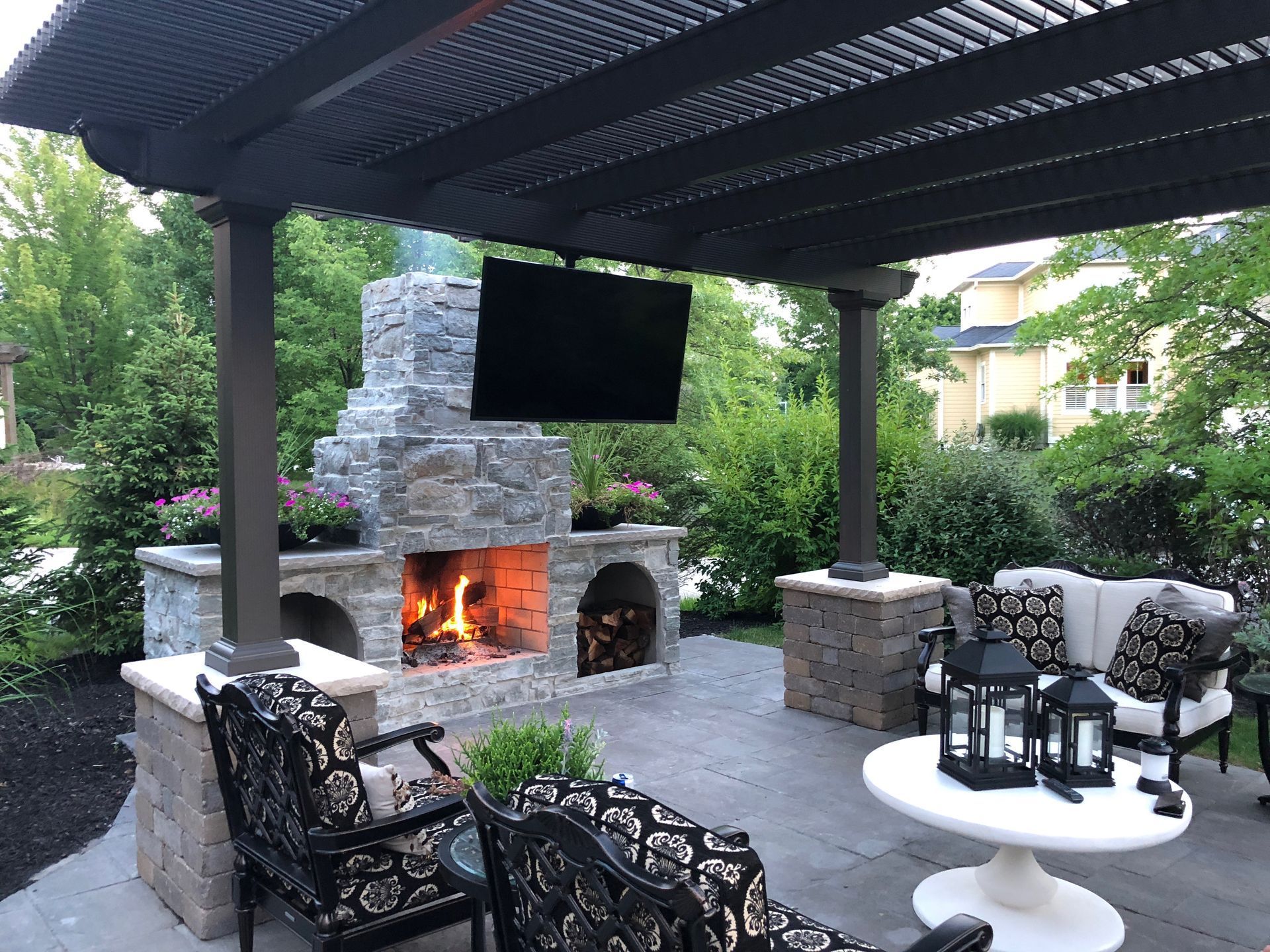 A patio with a fireplace and a flat screen tv.