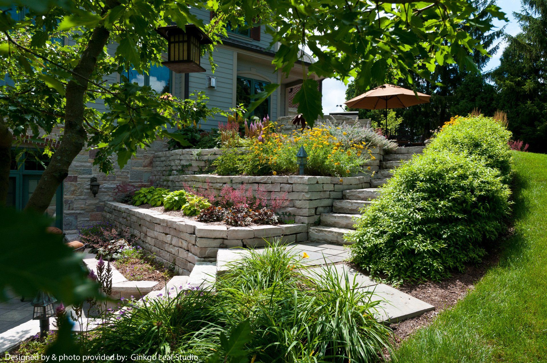 A lush green garden with stairs leading up to a house.