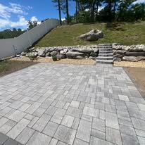 A patio with stairs leading up to it and a hill in the background.