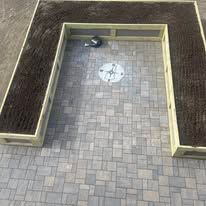 An aerial view of a brick walkway with a wooden bench in the middle.