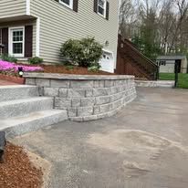 A brick wall with stairs leading up to a house.