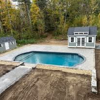 A swimming pool is being built in the backyard of a house.