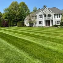 A large house with a lush green lawn in front of it.