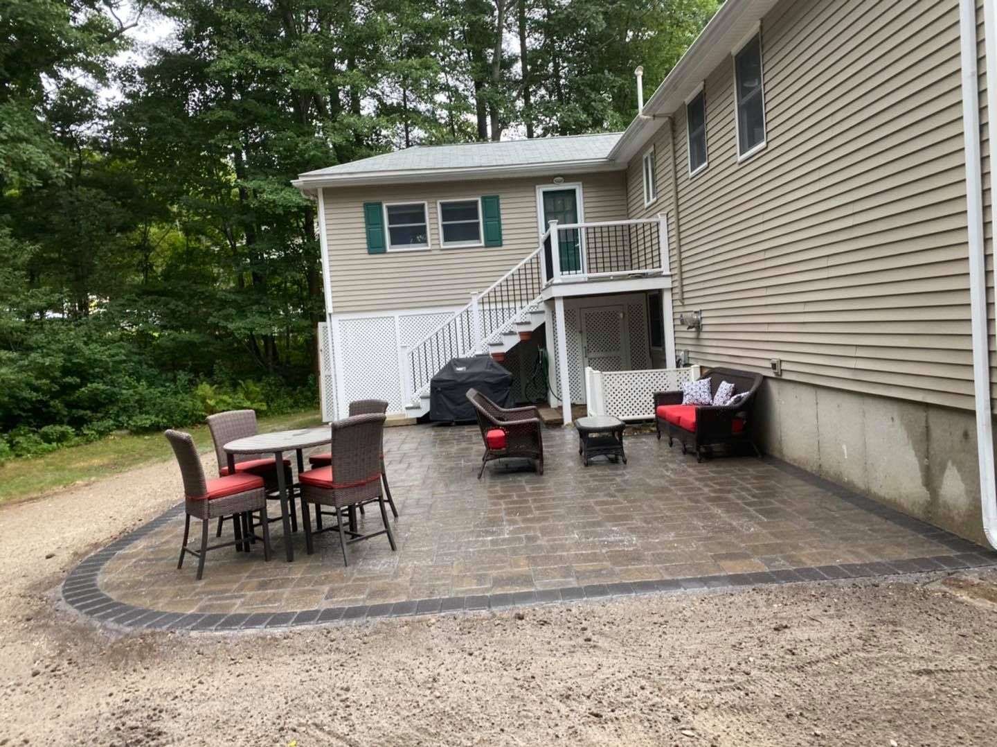 A patio with a table and chairs in front of a house.