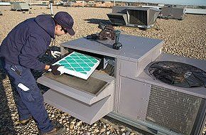 Man replacing filter on a rooftop air conditioning unit
