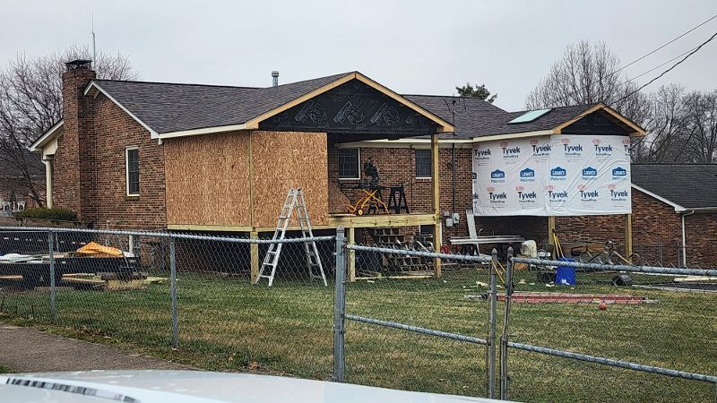 House under construction with exposed wood framing and sheathing. Covered in protective wrap.