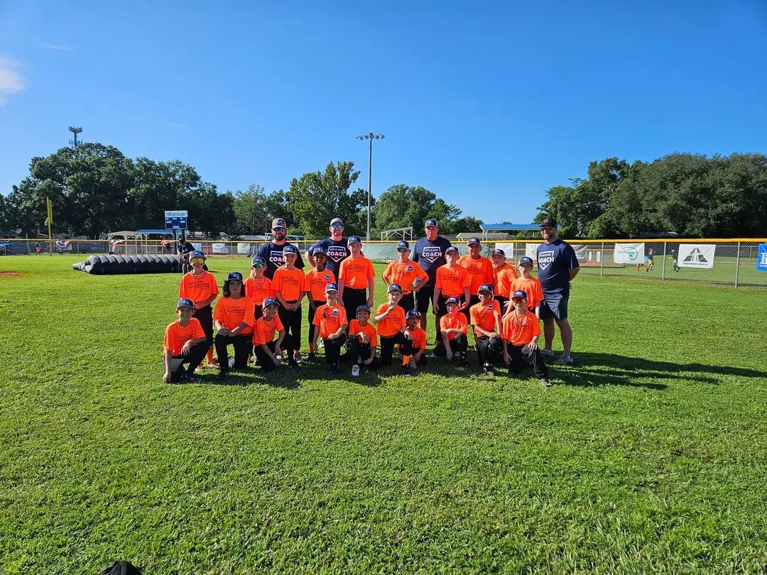 A group of children are posing for a picture on a field.