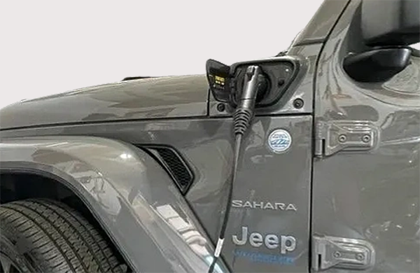 A jeep is plugged into a charging station.