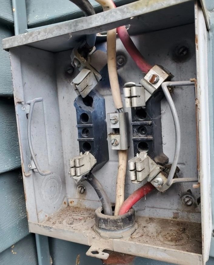A close up of an electrical box with wires coming out of it