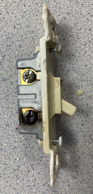 A close up of a light switch on a gray surface.