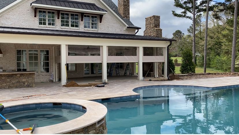 Backyard pool and hot tub beside a covered patio on a suburban home