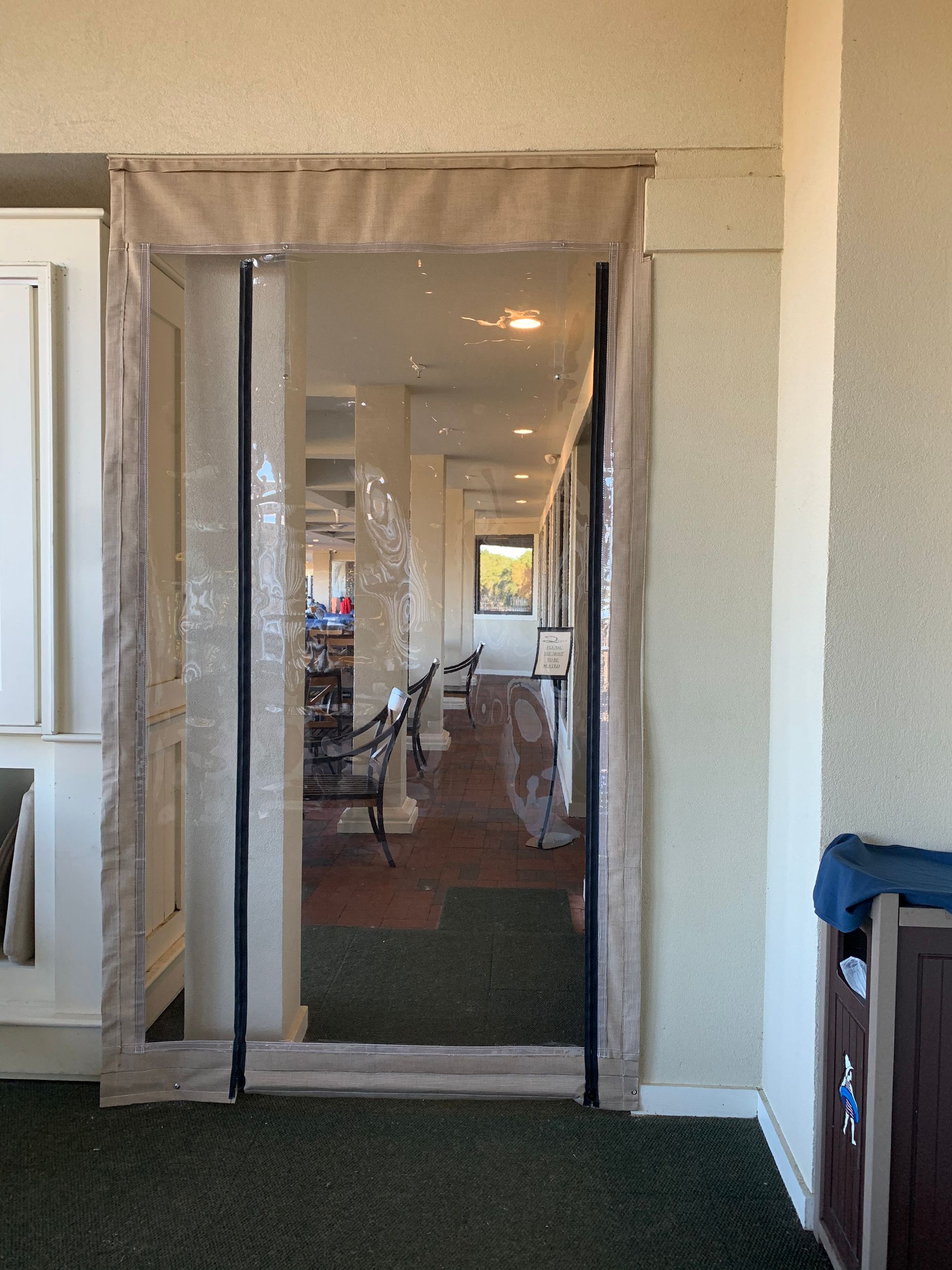 Mesh screen over an open doorway inside a home, with a narrow hallway visible beyond.