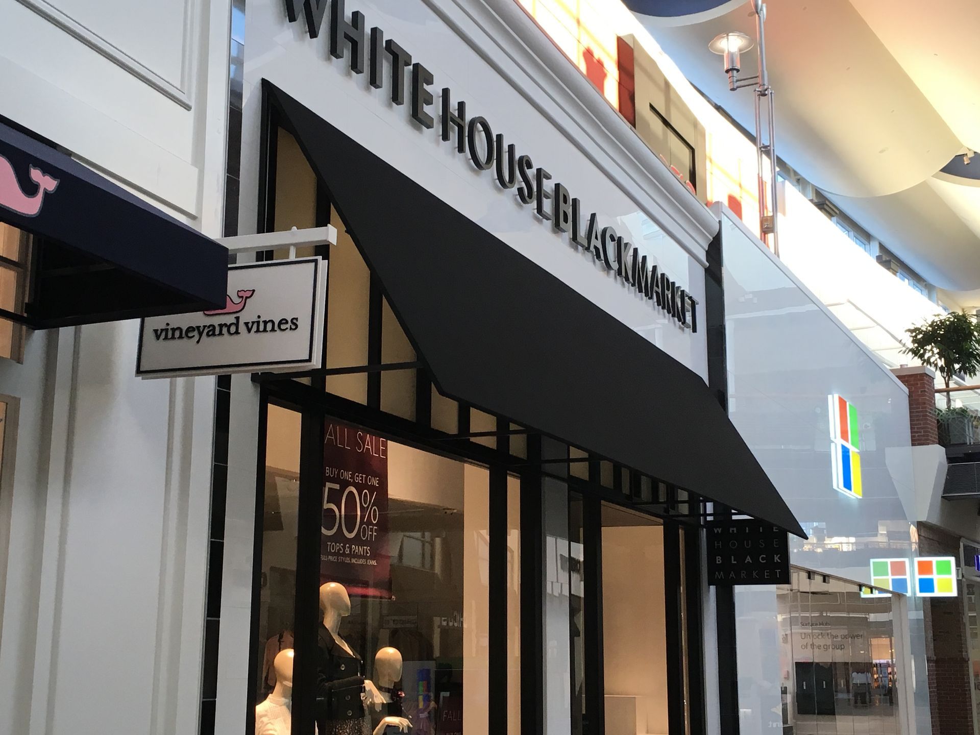 Storefront with a black awning and sign reading “WHITE HOUSE BLACK MARKET” in a shopping mall.