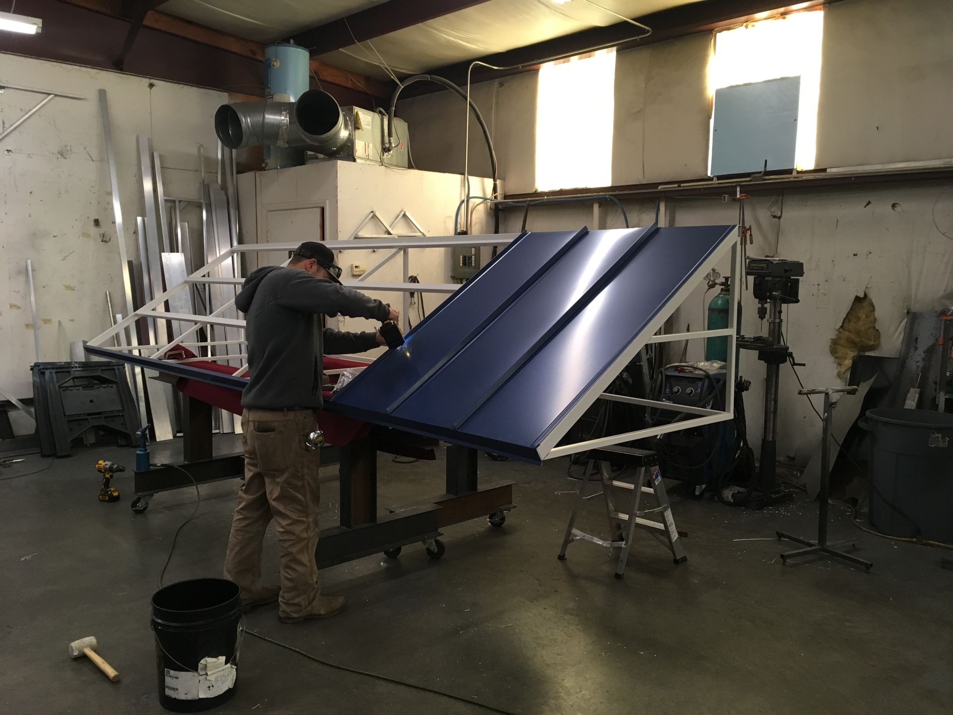 Person assembling a blue solar panel array in a workshop