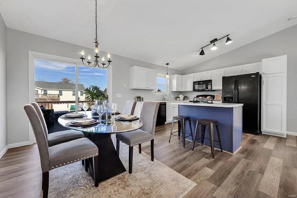 Modern kitchen with large island, stainless steel appliances, light cabinets, and bar seating.
