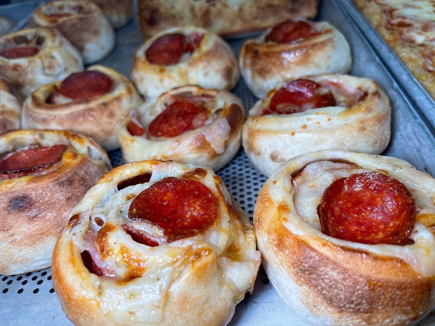 A bunch of pepperoni rolls are sitting on a tray.