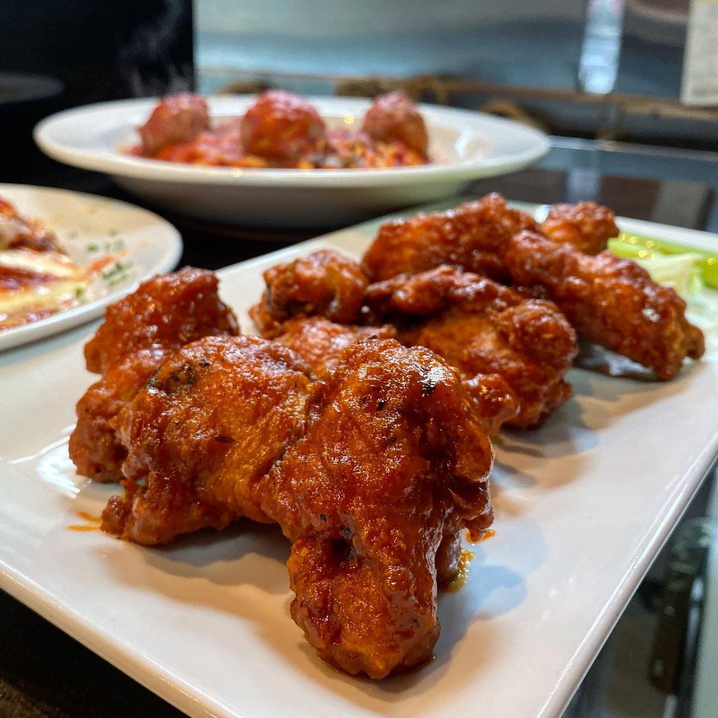 A white plate topped with chicken wings and sauce