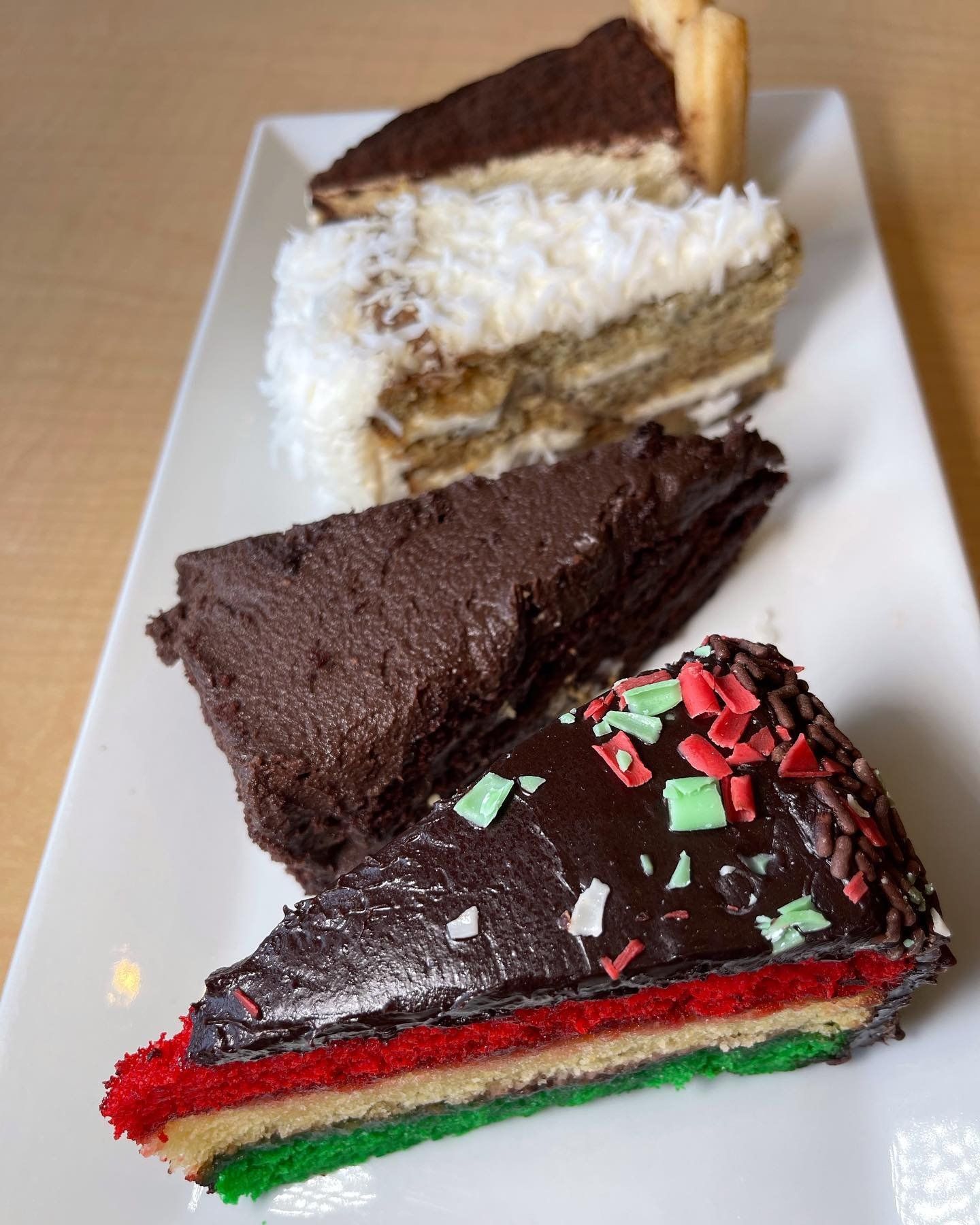 Three slices of cake are on a white plate