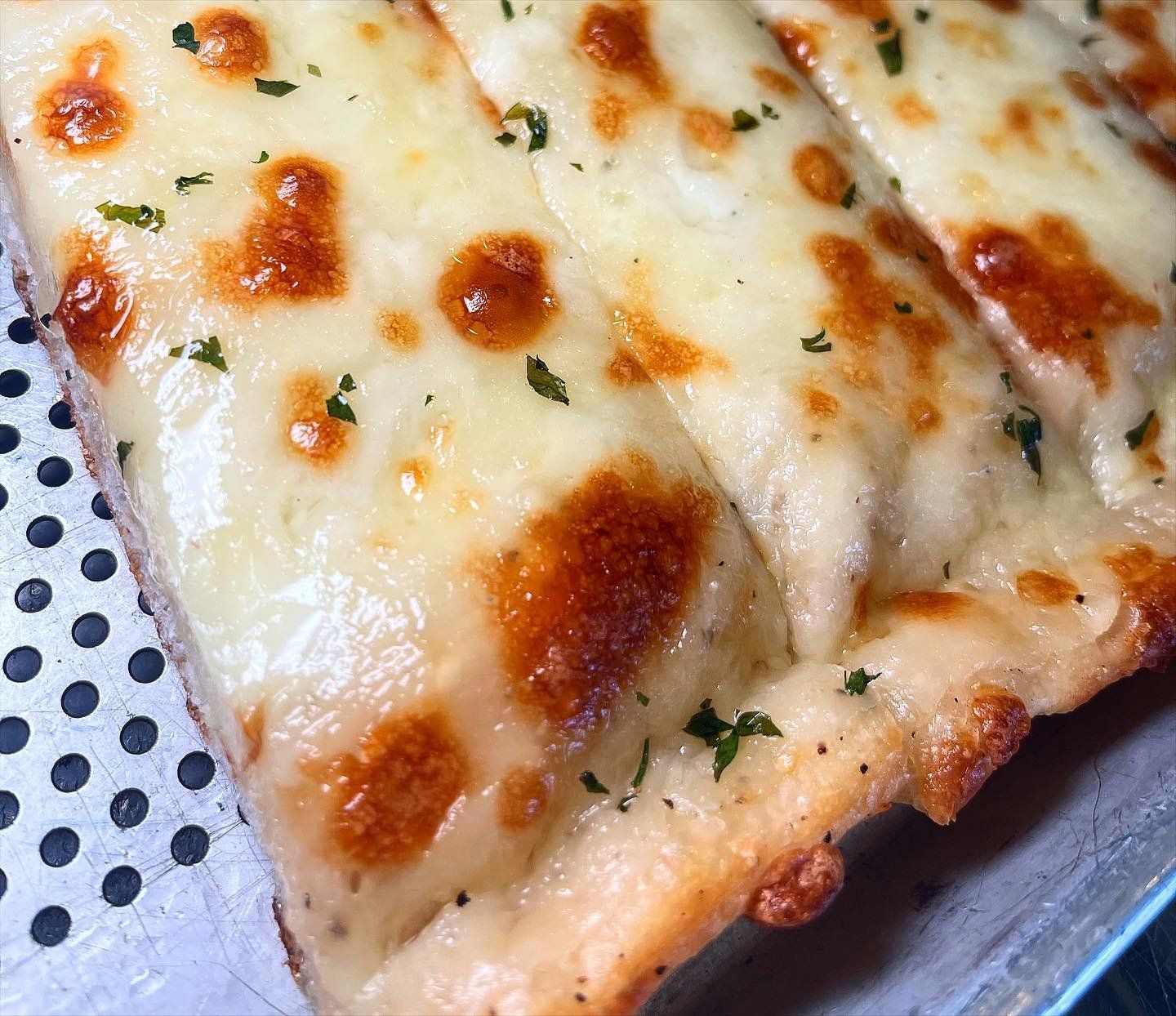 A close up of a piece of cheese bread on a plate